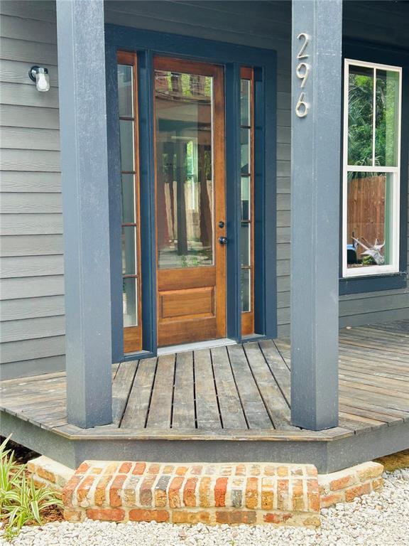 A wooden front door with glass panels sits on a porch with a brick step — 296 NW 12TH AVENUE, GAINESVILLE, FL