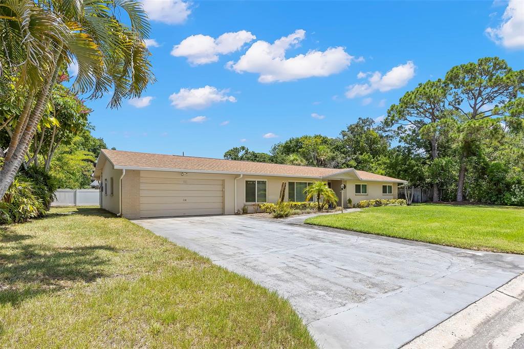 A single-story ranch-style house with a tan exterior, a two-car garage, and a concrete driveway — 2391 66TH TERRACE S, ST PETERSBURG, FL