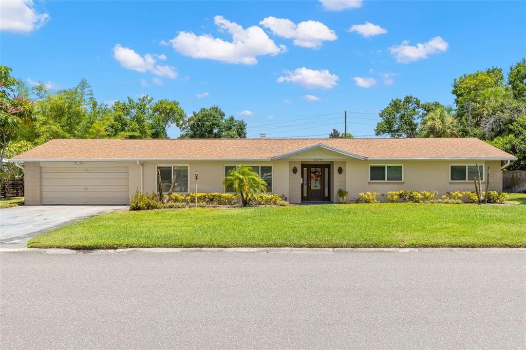 A single-story house with a tan exterior, a brown shingled roof, and an attached garage — 2391 66TH TERRACE S, ST PETERSBURG, FL