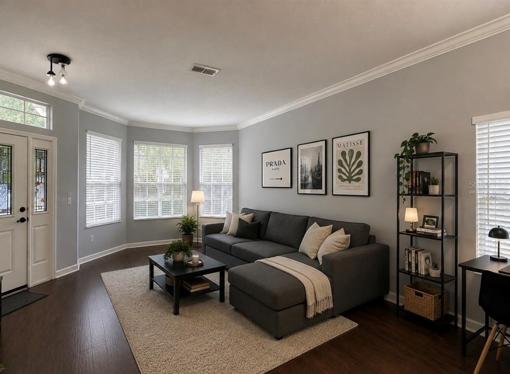 A living room features a dark gray sectional sofa, a coffee table, and wall art — 15245 STONEBRIAR WAY, ORLANDO, FL
