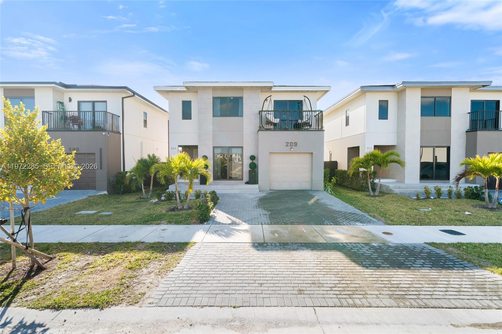 A two-story residential house with a paved driveway, a garage, and a second-floor balcony — 209 NW 13th Pl, Florida City FL 33034, FLORIDA CITY, FL
