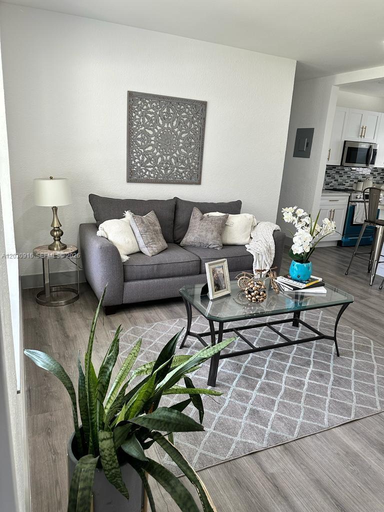 A living room features a gray sofa, a glass coffee table, and a patterned rug — 1029 SW 1st Ave, Pompano Beach FL 33060, POMPANO BEACH, FL