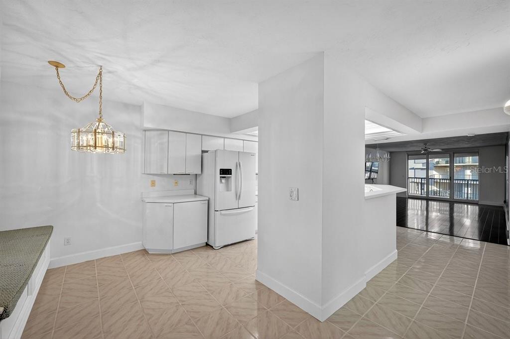 A kitchen with white cabinets, a white refrigerator, and light-colored tile flooring — 4555 S ATLANTIC AVENUE UNIT 4411, PORT ORANGE, FL