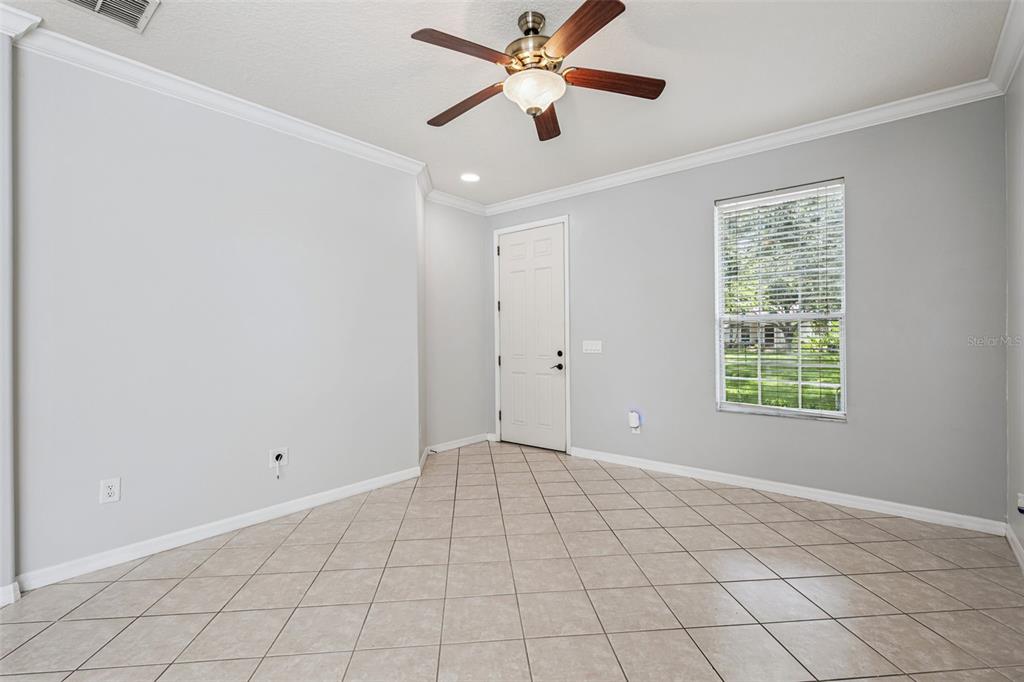 A room with light gray walls, tile flooring, a ceiling fan, and a single window — 5451 KUMQUAT LOOP, WINDERMERE, FL