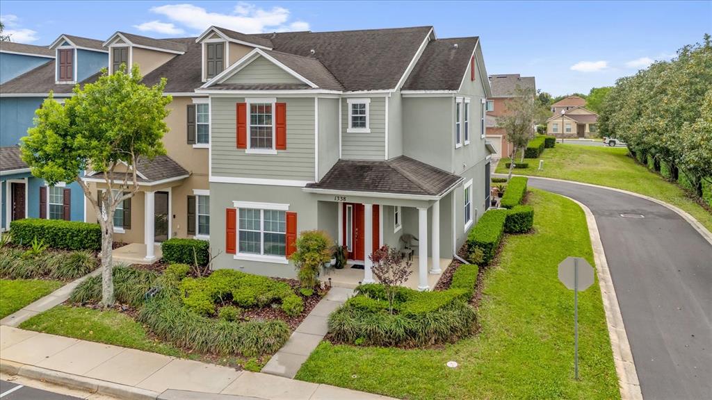 A two-story townhouse with light green siding, red shutters, and a covered front porch — 1338 ALSTON BAY BOULEVARD, APOPKA, FL