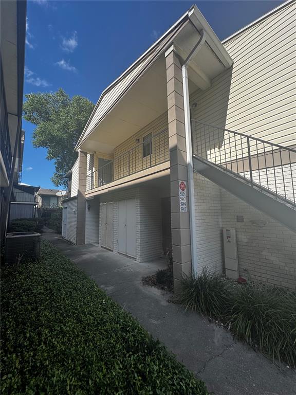 An exterior view of a two-story apartment building with a metal staircase and brick siding — 5917 VILLAGE CIRCLE UNIT 5917, ORLANDO, FL
