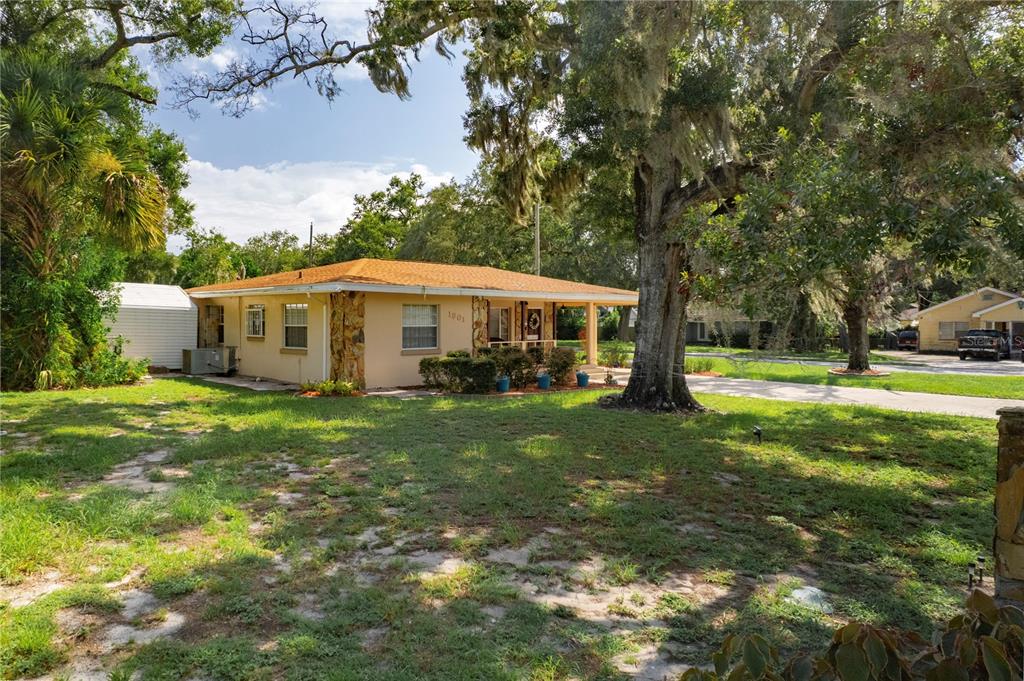 A single-story house with a tan exterior, stone accents, and a covered porch sits outdoors — 1901 E PARIS STREET, TAMPA, FL