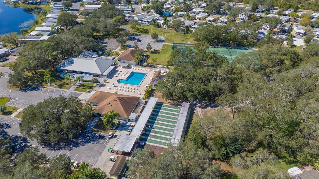 An aerial view shows a community center with a swimming pool, tennis courts, and shuffleboard courts — 6 RED QUILL CIRCLE, LAKE WALES, FL
