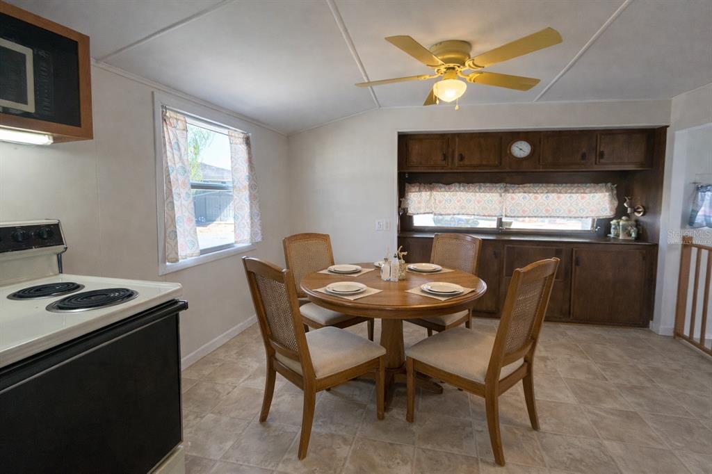 A dining area with a round wooden table, four chairs, and dark wood cabinetry — 6 RED QUILL CIRCLE, LAKE WALES, FL
