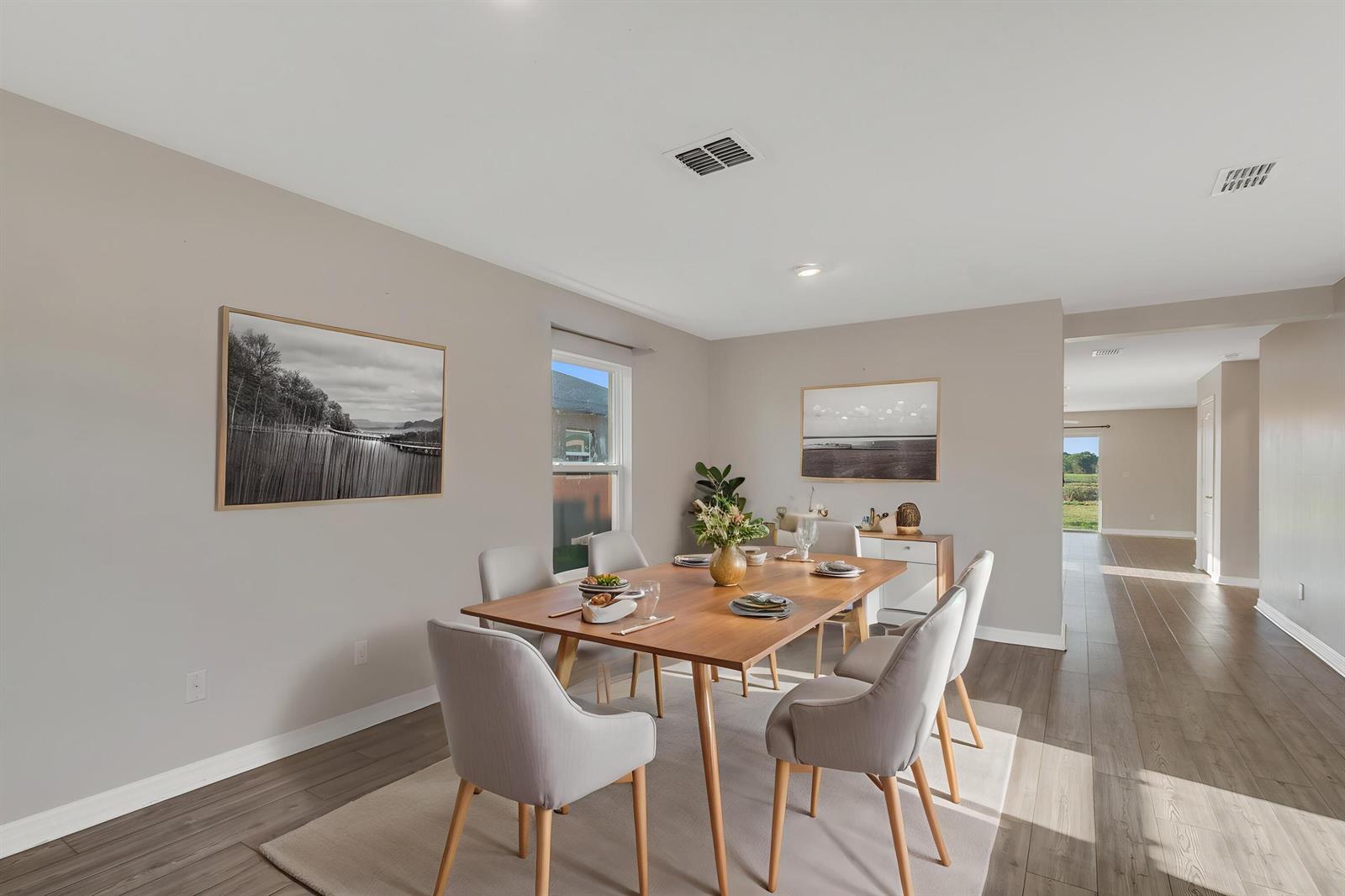 A dining room features a wooden table, six grey chairs, and two framed wall prints — 5532 Imagination Drive, Fort Pierce FL 34947, FORT PIERCE, FL