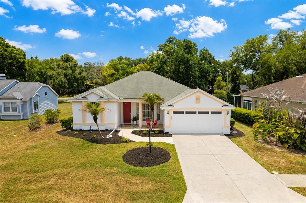 A single-story house with a white exterior, red front door, and a two-car garage — 3406 SILVERSTONE COURT, PLANT CITY, FL