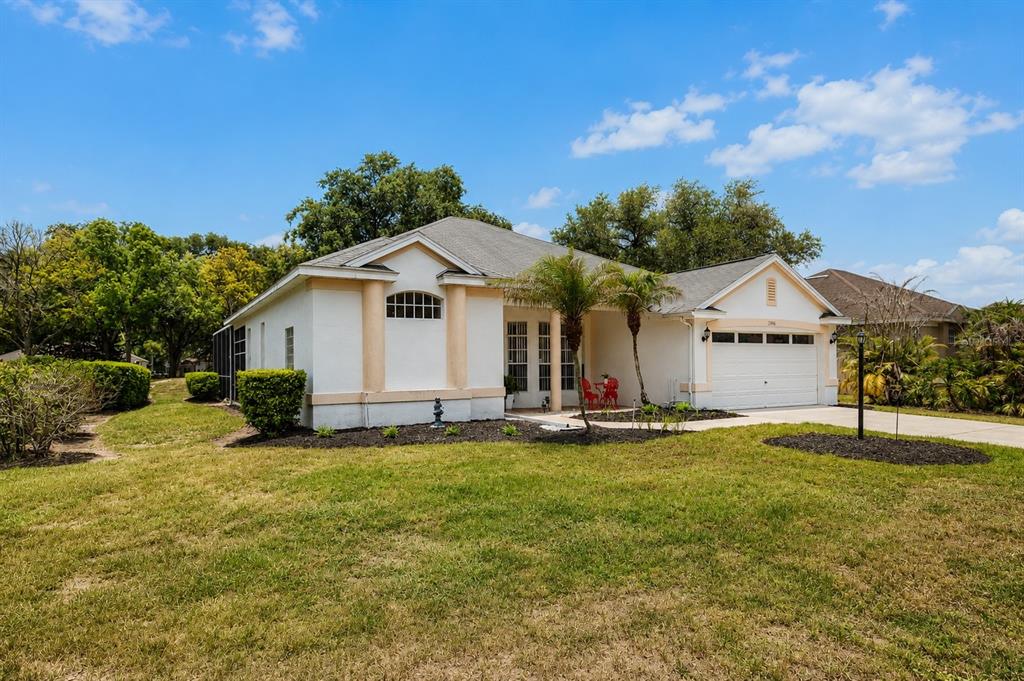 A single-story house with a white stucco exterior, tan trim, and a two-car garage — 3406 SILVERSTONE COURT, PLANT CITY, FL