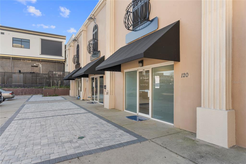 The exterior of a commercial building features a paved parking area and black fabric awnings — 120 SW BROADWAY STREET, OCALA, FL