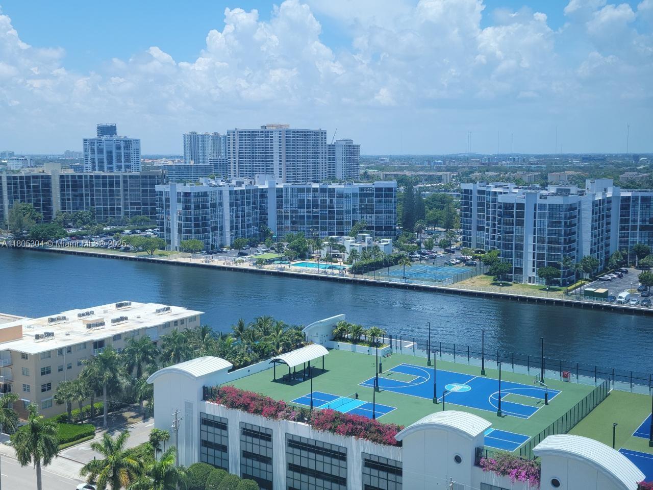 An elevated view shows a canal separating residential buildings from a complex with tennis courts — 2501 S Ocean Dr # 1634, Hollywood FL 33019, HOLLYWOOD, FL
