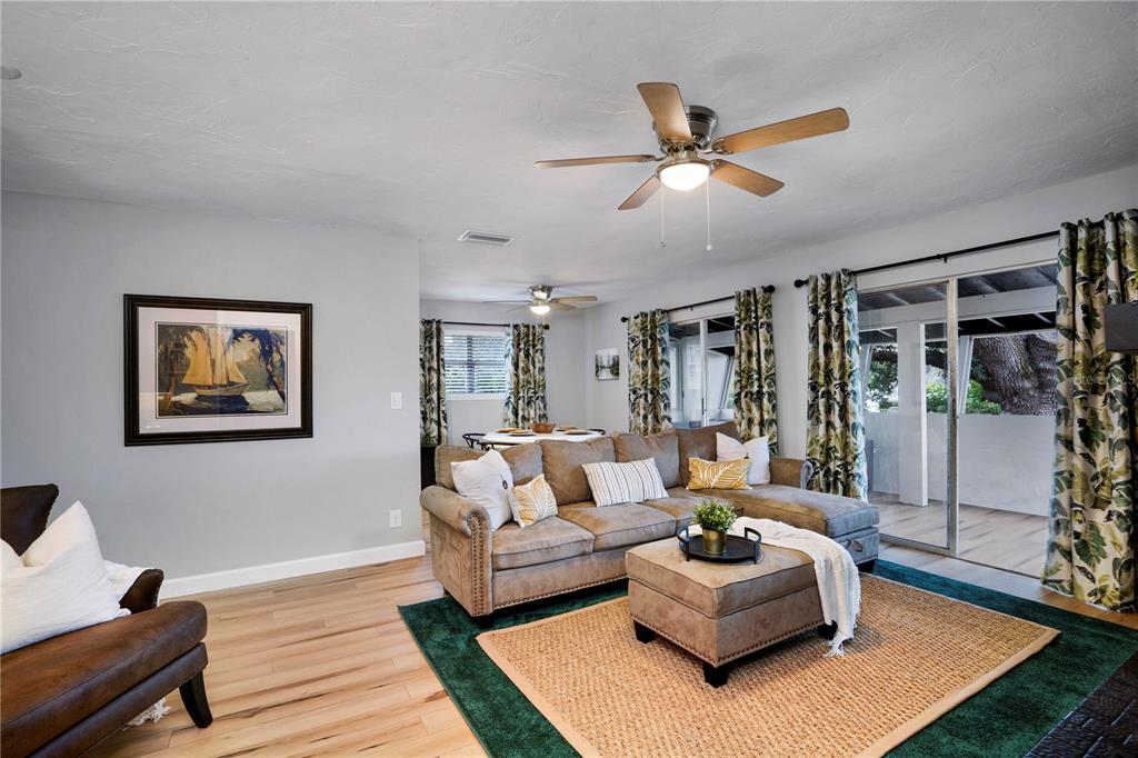A living room features a sectional sofa, an ottoman, and sliding glass doors to a patio — 4705 HOLLINGSWORTH AVENUE, SARASOTA, FL