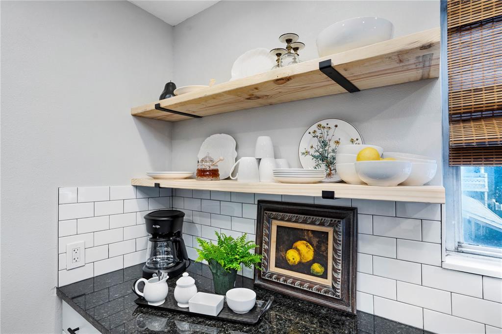 A kitchen corner features open wood shelving, white subway tile backsplash, and black granite countertops — 4705 HOLLINGSWORTH AVENUE, SARASOTA, FL
