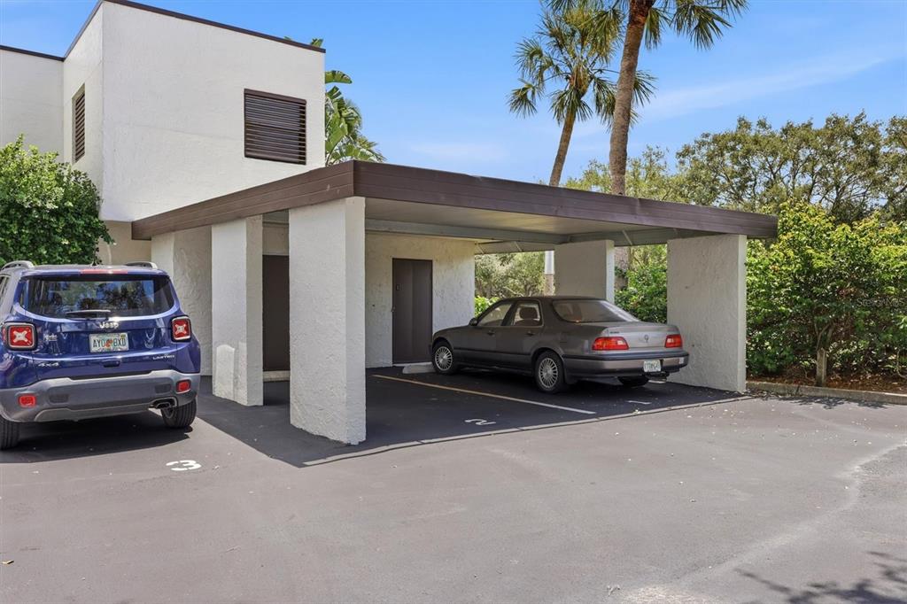 A two-story building features a covered carport with two parking spaces and two cars — 3508 RICHWOOD LINK UNIT 55, SARASOTA, FL
