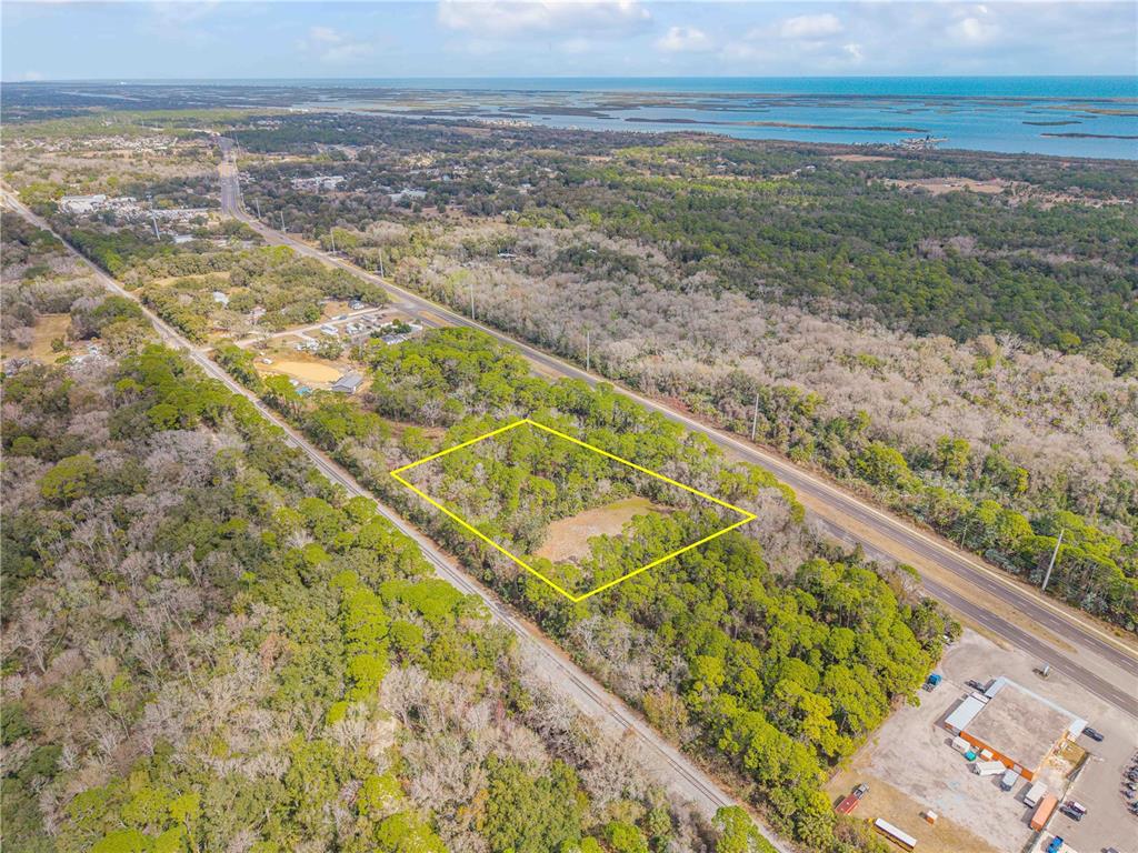 An aerial view shows a rectangular plot of land outlined in yellow near a highway — 370 S US HIGHWAY 1, OAK HILL, FL
