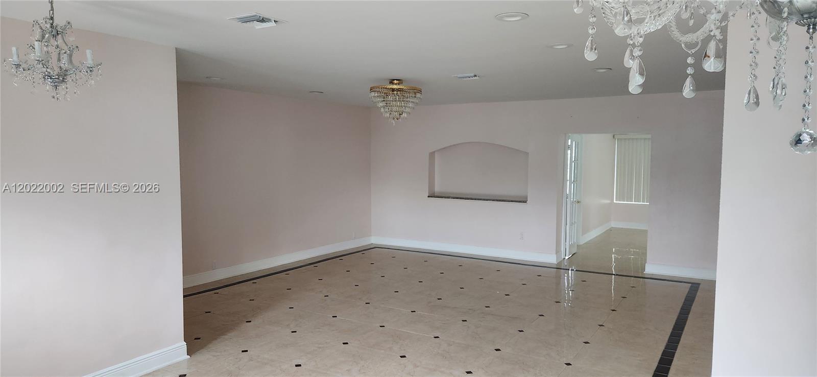 A spacious room features light-colored tile flooring with black accents and three crystal chandeliers — 5260 SW 9th St, Plantation FL 33317, PLANTATION, FL