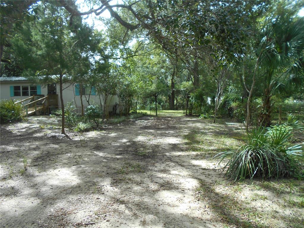 A mobile home exterior features a wooden ramp leading to the front entrance — 20425 NE 143RD STREET, SALT SPRINGS, FL