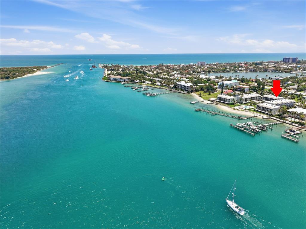 An aerial view shows a coastal condominium complex with boat docks along a turquoise waterway — 1300 SEAWAY DRIVE UNIT C1, HUTCHINSON ISLAND, FL