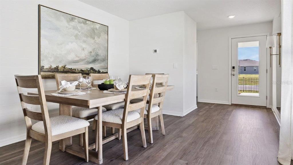 A dining area features a wooden table with six chairs, white walls, and wood-look flooring — 4423 LAKE FOX DRIVE, LAKELAND, FL