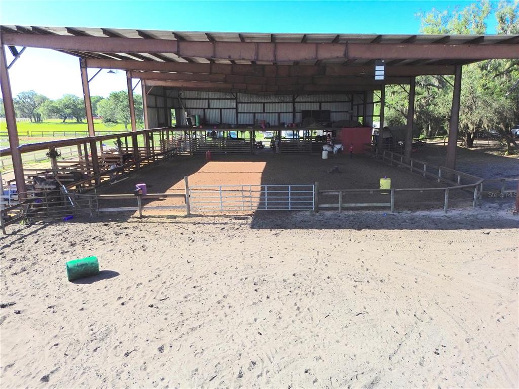 An outdoor covered horse riding arena with a dirt floor and wooden fencing — 3046 N BOWDEN ROAD, AVON PARK, FL