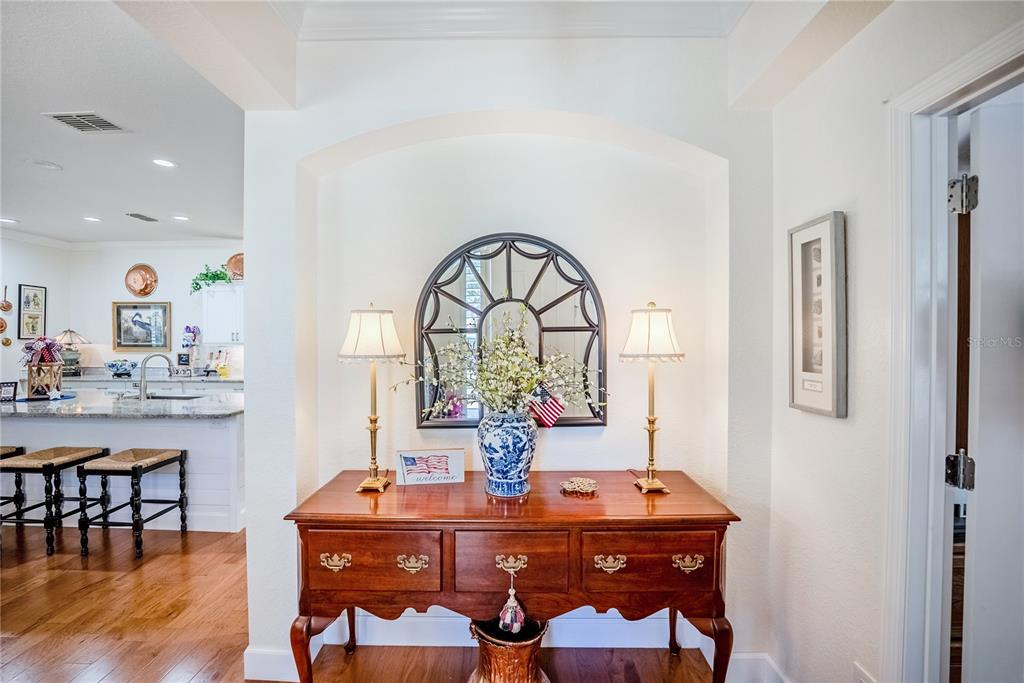 A wooden console table with lamps and a mirror sits in a white-walled entryway — 6631 SW 91ST CIRCLE, OCALA, FL