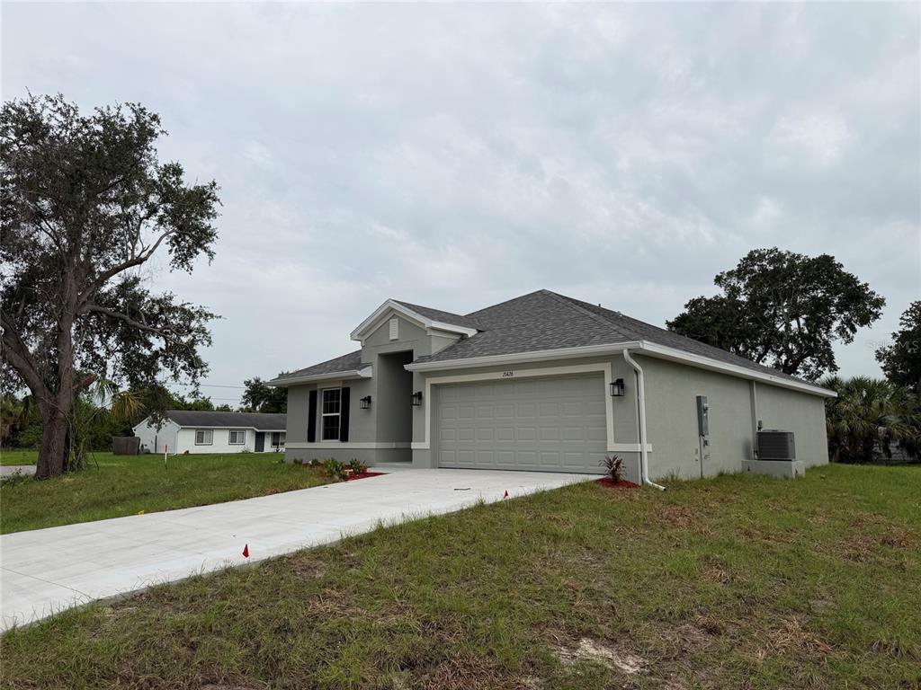 A single-story gray house with a two-car garage and a concrete driveway — 21426 DEKALS AVENUE, PORT CHARLOTTE, FL