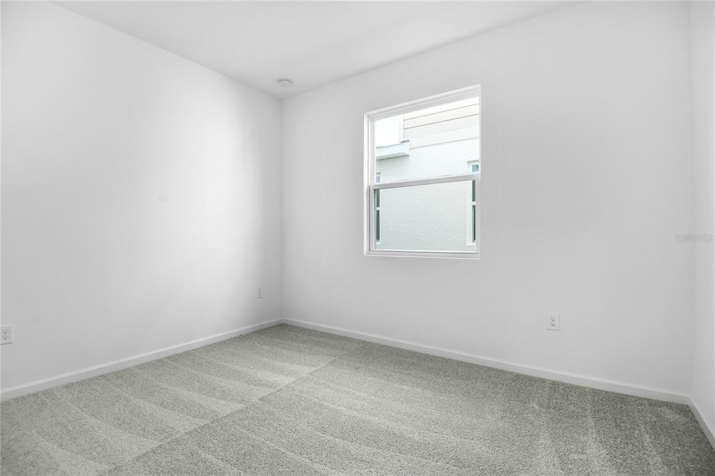 An empty bedroom features white walls, gray carpet, and a single window — 6166 DAPHNE STREET, LAKE HAMILTON, FL