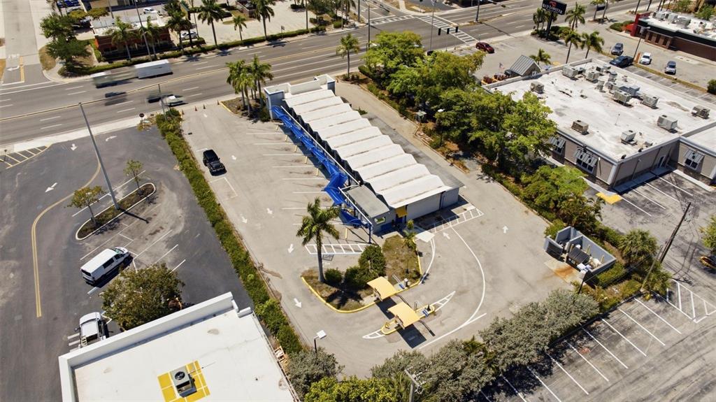 An aerial view shows a car wash facility with a long, white-roofed structure and parking — 3821 CLEVELAND AVENUE, FORT MYERS, FL