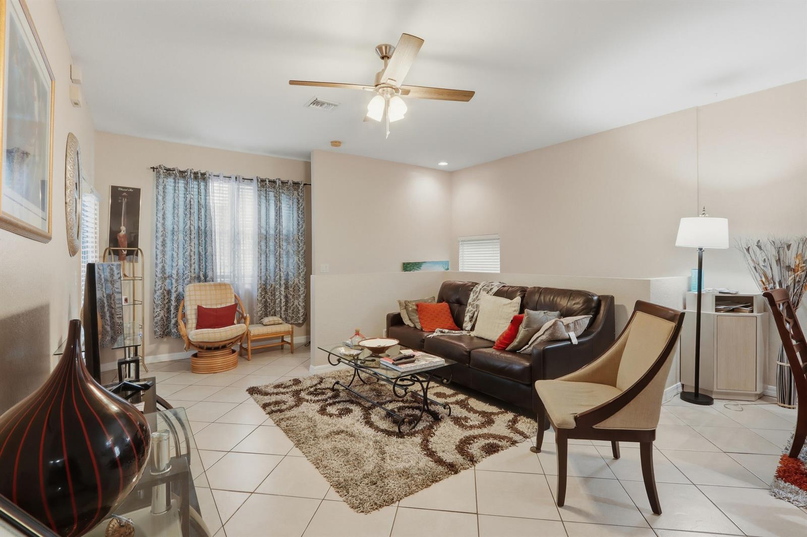 A living room features tile flooring, a brown leather sofa, and a ceiling fan — 3108 Grandiflora Drive, FL 33467, FL