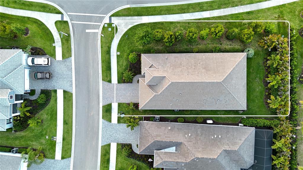 An aerial view shows a residential house with a paved driveway and landscaped yard — 2550 WILD CHERRY PATH, SARASOTA, FL