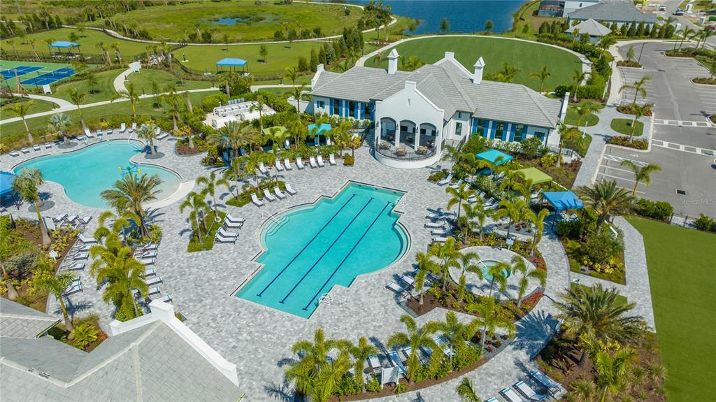 An aerial view shows a community clubhouse with two swimming pools and surrounding lounge areas — 2550 WILD CHERRY PATH, SARASOTA, FL