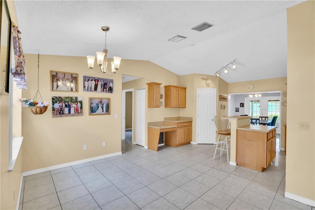 A dining area with tile floors, a chandelier, and a built-in desk near the kitchen — SEBASTIAN, FL