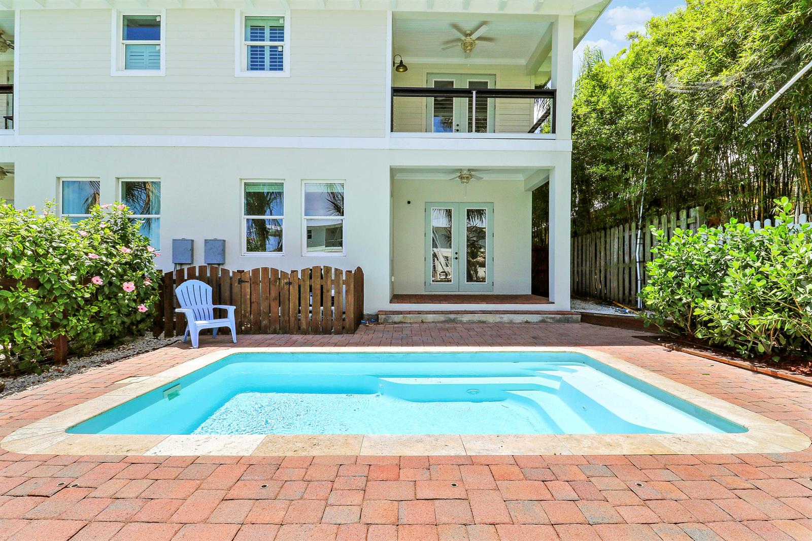 A two-story house with a backyard pool, brick patio, and a wooden fence — 3997 SE Barcelona Street, Stuart FL 34997, STUART, FL