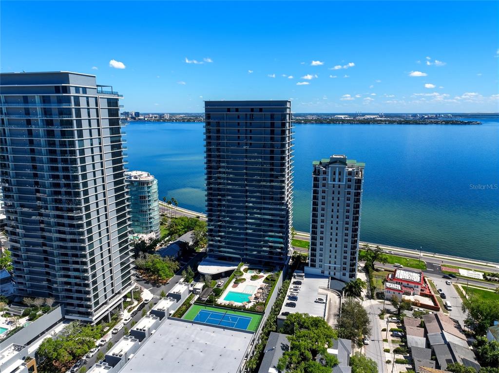 An aerial view shows three tall residential towers situated along a large body of water — 3101 BAYSHORE BOULEVARD UNIT 504, TAMPA, FL