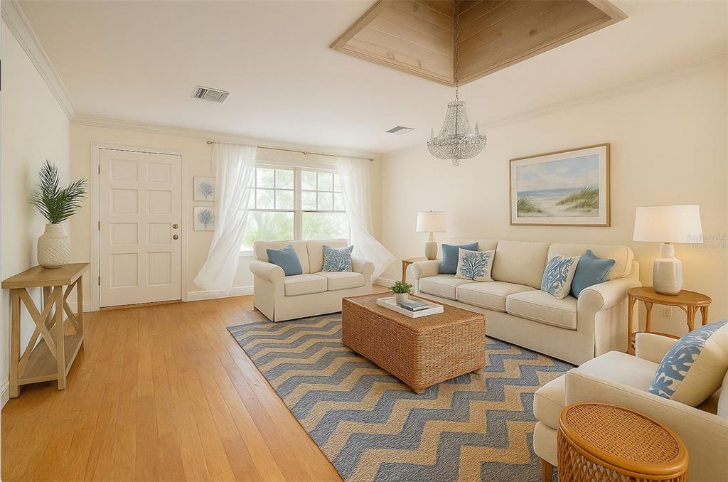 A living room features a tray ceiling, a chandelier, a chevron rug, and coastal decor — 226 OGDEN STREET, SARASOTA, FL