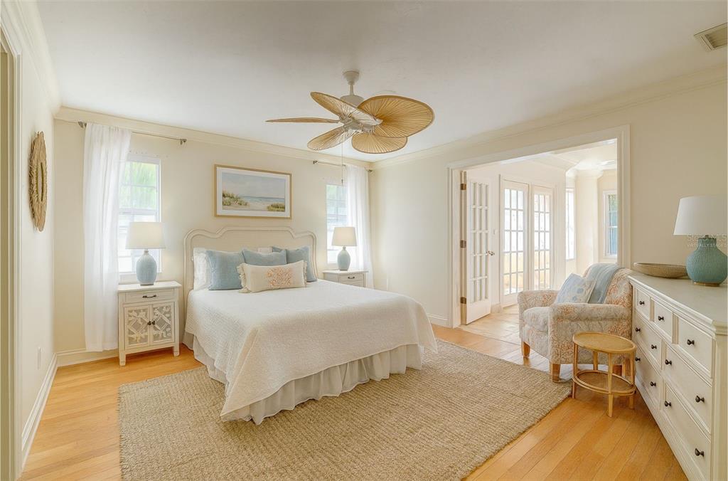 A bedroom with a queen bed, ceiling fan, hardwood floors, and an adjacent sunroom — 226 OGDEN STREET, SARASOTA, FL