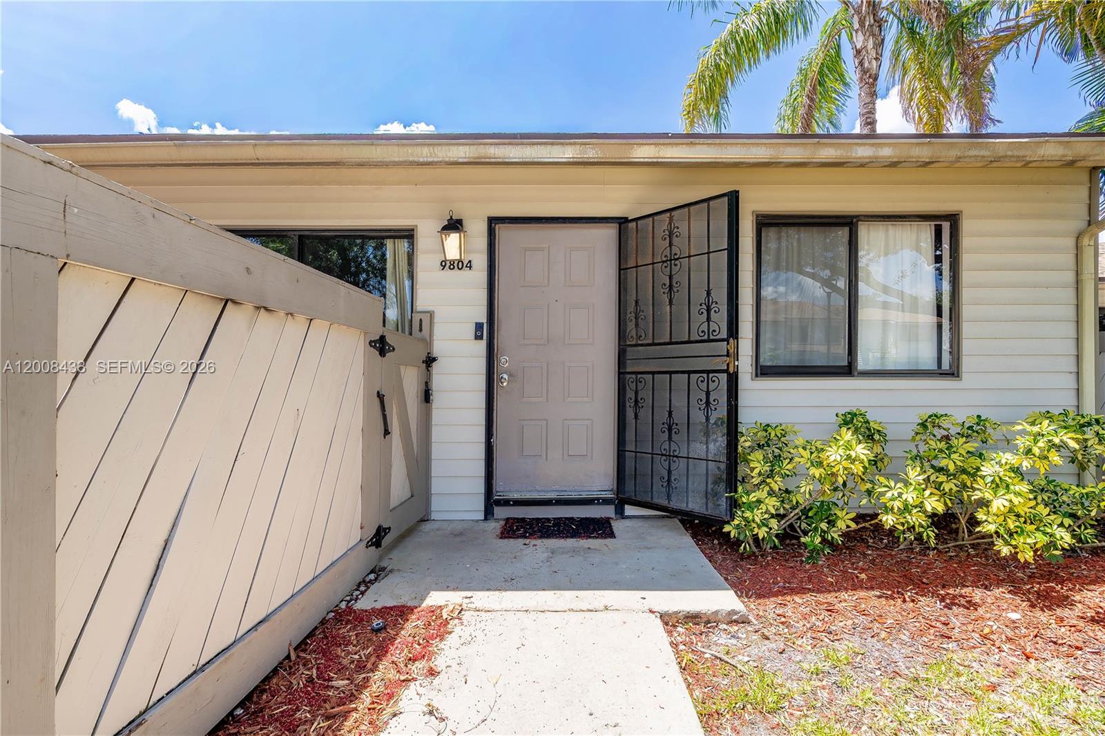 A beige house exterior features a front door with a decorative metal security gate — 9804 NW 37th St # 3E, Sunrise FL 33351, SUNRISE, FL