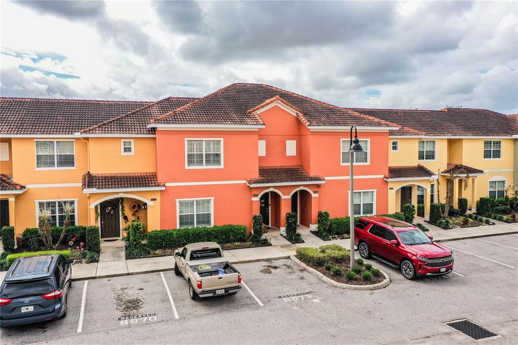 A multi-unit residential building with orange and yellow stucco walls and a tiled roof — 8972 CALIFORNIA PALM ROAD, KISSIMMEE, FL