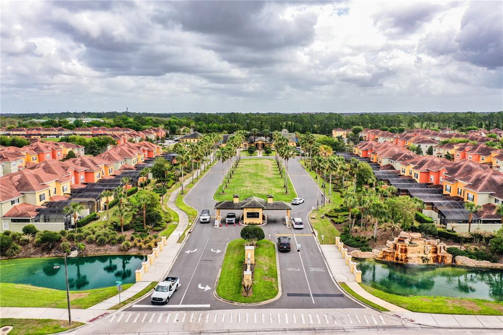 An aerial view shows a gated residential community entrance with palm trees and ponds — 8972 CALIFORNIA PALM ROAD, KISSIMMEE, FL