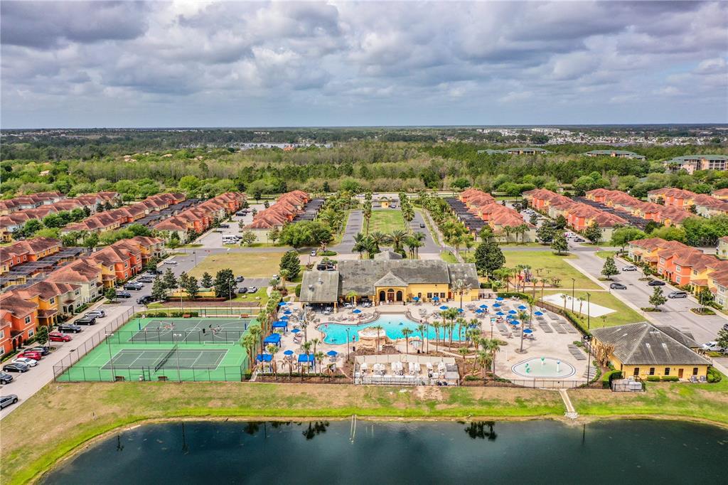 An aerial view of a residential community featuring a clubhouse, swimming pool, and tennis courts — 8972 CALIFORNIA PALM ROAD, KISSIMMEE, FL