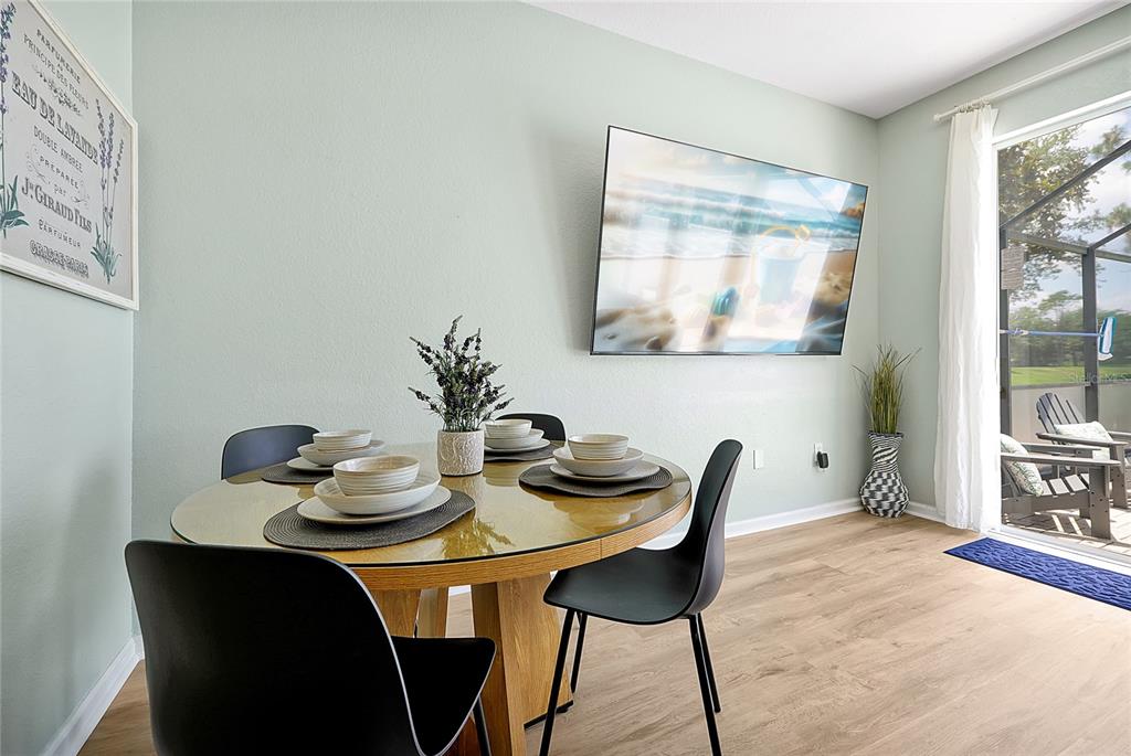 A dining area features a round glass table, four black chairs, and a wall-mounted television — 2500 RENSHAW STREET, KISSIMMEE, FL