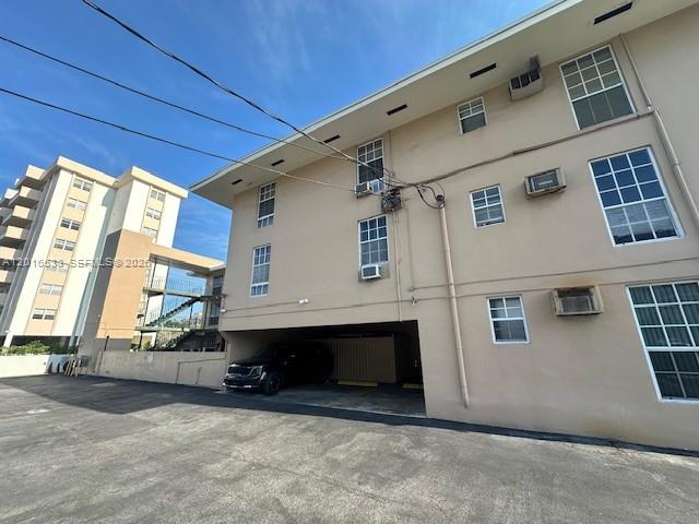 The exterior of a multi-story apartment building features a covered parking area and balconies — 1400 S Douglas Rd # 14, Coral Gables FL 33134, CORAL GABLES, FL