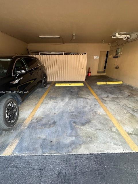 A covered parking space features a black SUV parked next to a numbered storage unit — 1400 S Douglas Rd # 14, Coral Gables FL 33134, CORAL GABLES, FL