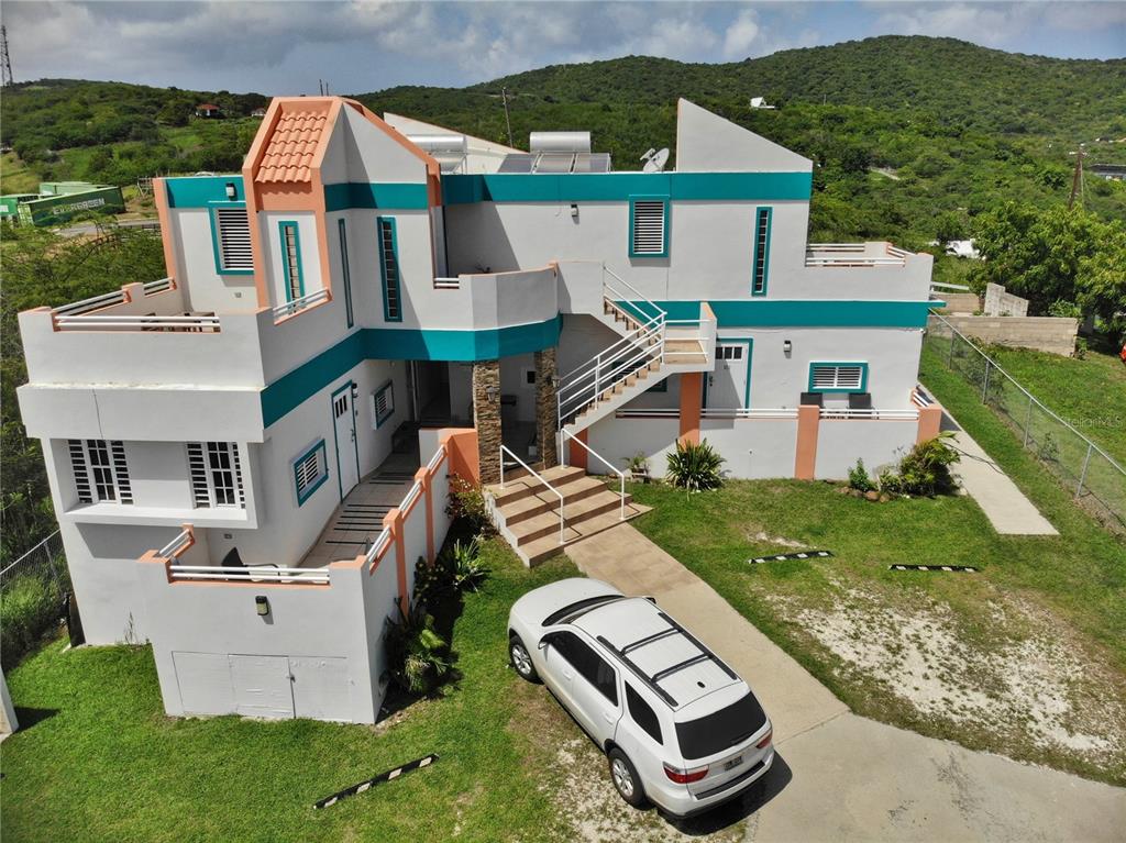 An aerial view of a multi-level house with white, teal, and peach exterior paint — 250 LAS DELICIAS, CULEBRA, PR