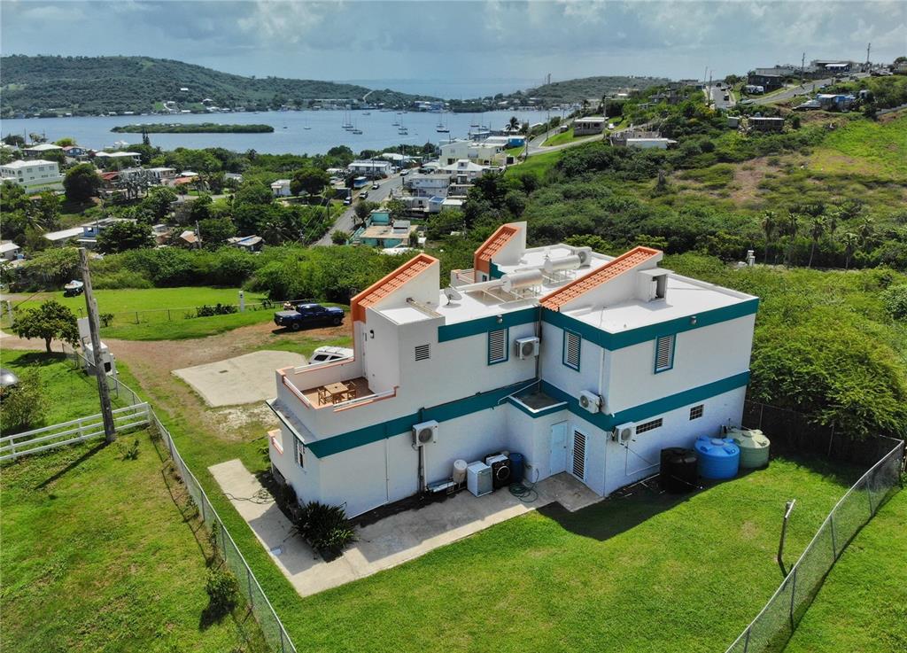 An aerial view of a two-story white house with teal trim and a rooftop terrace — 250 LAS DELICIAS, CULEBRA, PR