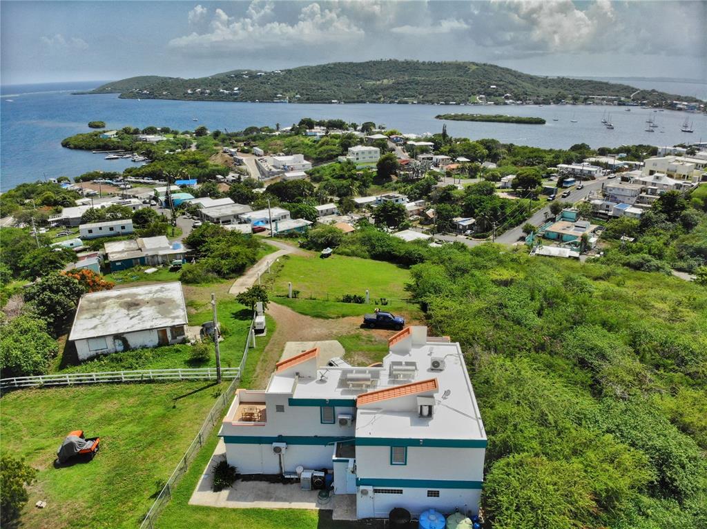 An aerial view shows a white house with a teal stripe and a large yard — 250 LAS DELICIAS, CULEBRA, PR