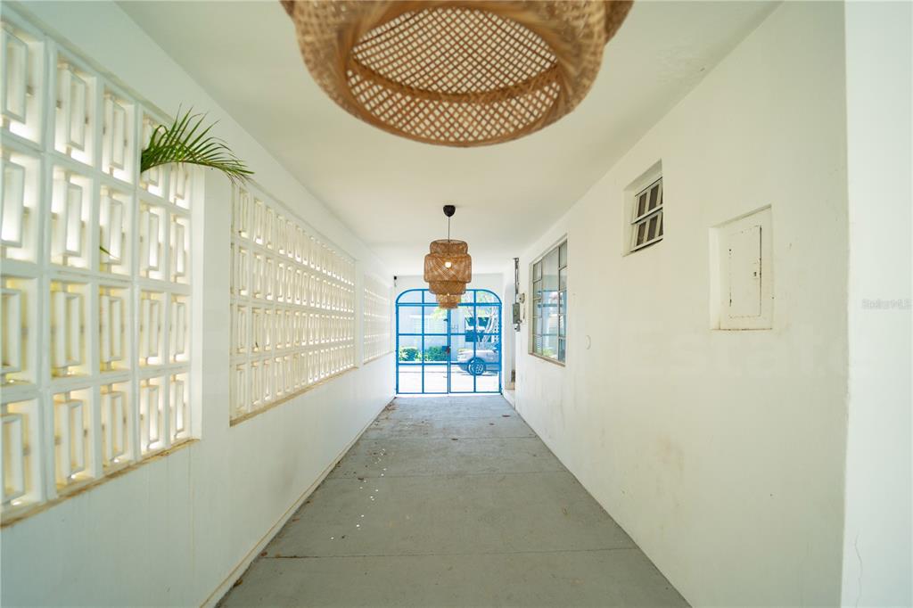 A covered outdoor walkway features white walls, a concrete floor, and two hanging woven light fixtures — 2019 CACIQUE STREET, SAN JUAN, PR